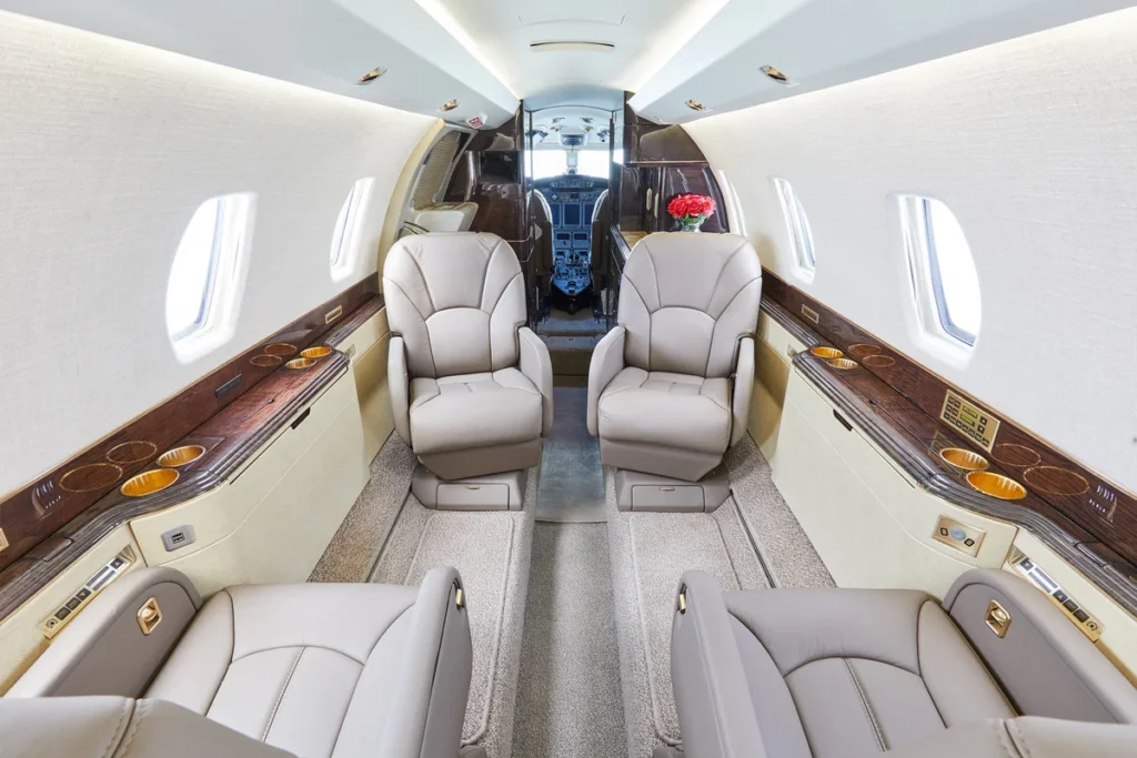 Private jet rental interior featuring wide leather seats and spacious cabin layout.