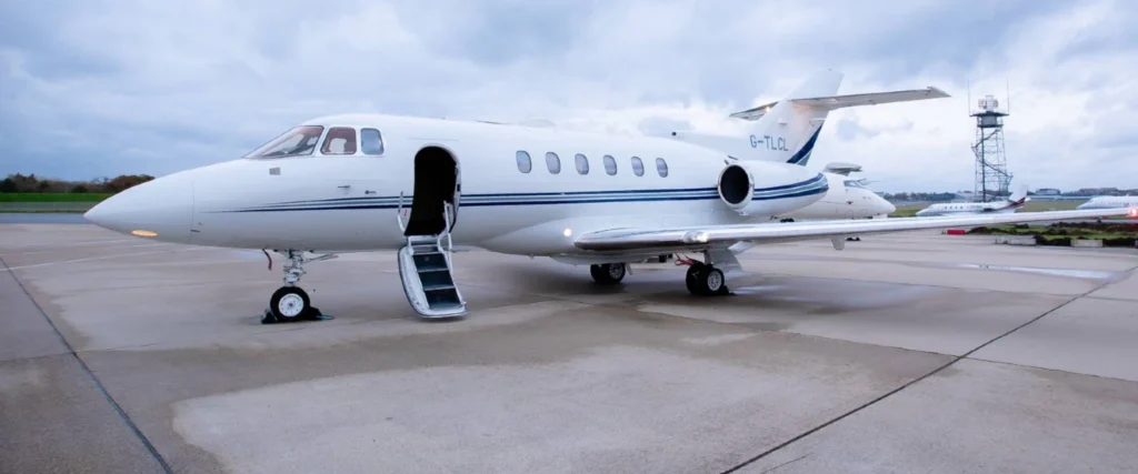 Private air travel jet parked on runway with stairs extended for boarding.