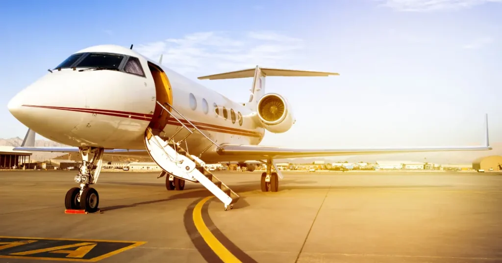 Private flight booking jet parked on the tarmac with its staircase down at sunset