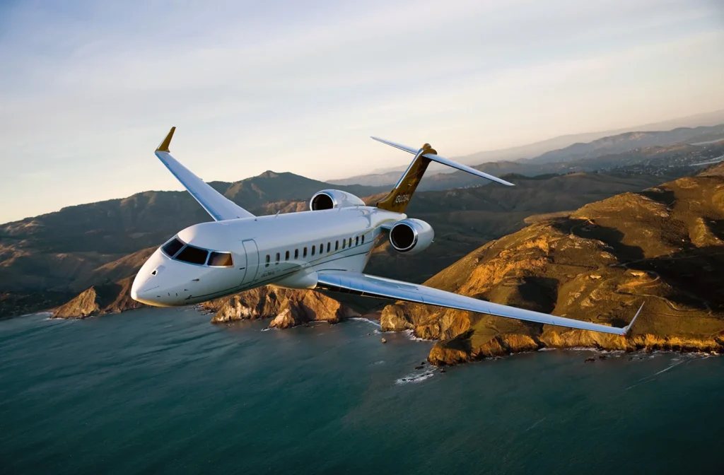 Private jet cruising over coastline cliffs during sunset
