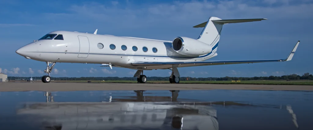 Charter flight services image of a private jet parked on the runway with reflection on wet tarmac.