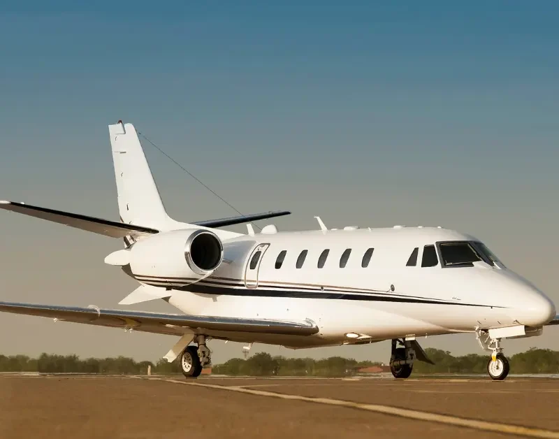 Private jet concierge service aircraft on runway ready for boarding under clear sky.