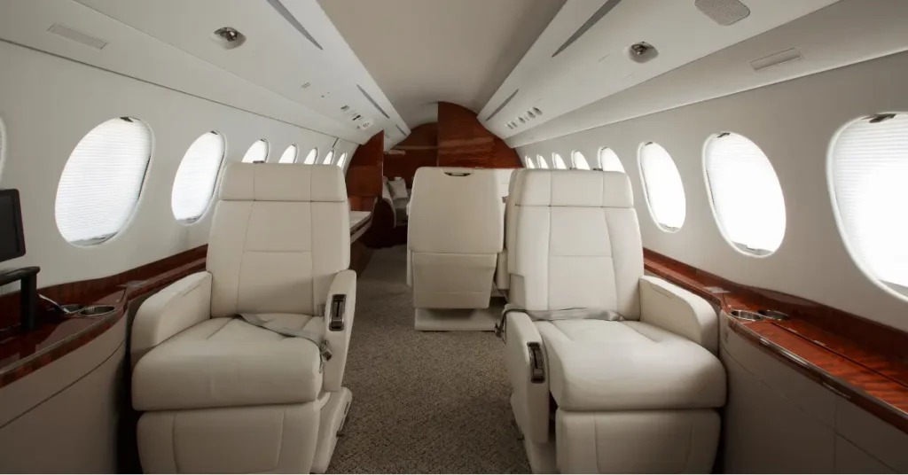 Charter plane booking experience shown through plush white seating and spacious jet interior.