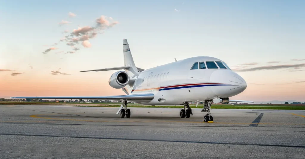 Luxury air travel with white private jet parked on runway at sunset.