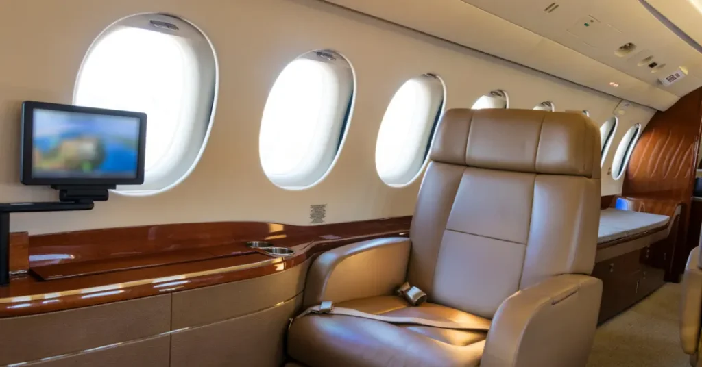 Private jet amenities include reclining leather seats and personal entertainment screen in a sleek cabin.