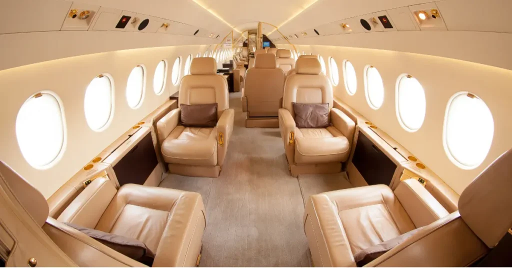 Private jet flight interior showcasing spacious leather seats and luxurious ambient lighting.