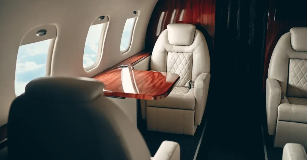 Private jet flights featuring elegant leather seating and panoramic window views above the clouds.