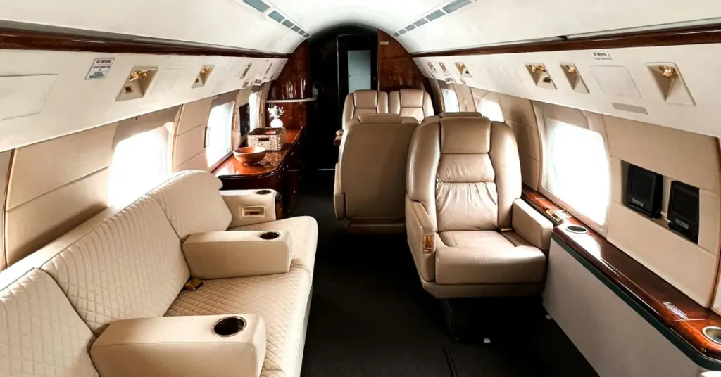 Luxury travel services shown in jet cabin with plush seating and elegant wood accents.