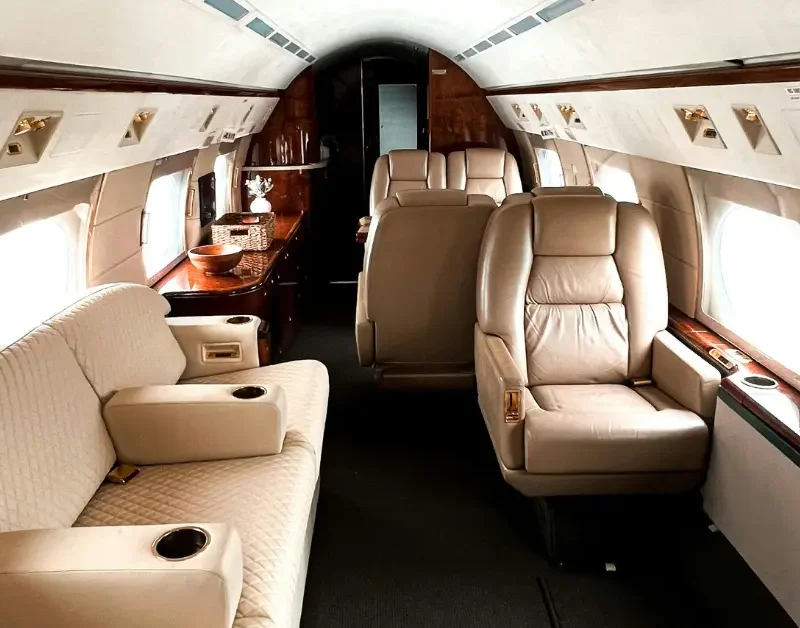 Private jet rental cabin featuring plush seating, wood accents, and elegant interior design.